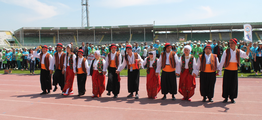 Etkinliğe halk oyunları oynayarak katılan sporcuların dans ederkenki görüntüsü