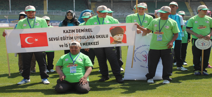Okullarının pankartı ile poz veren bir grup öğrenci